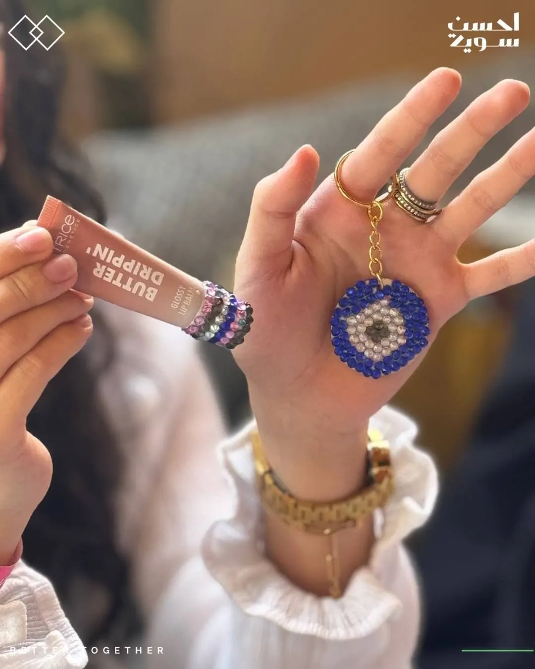 A hand shows a rhinestone keyring and a Catrice product