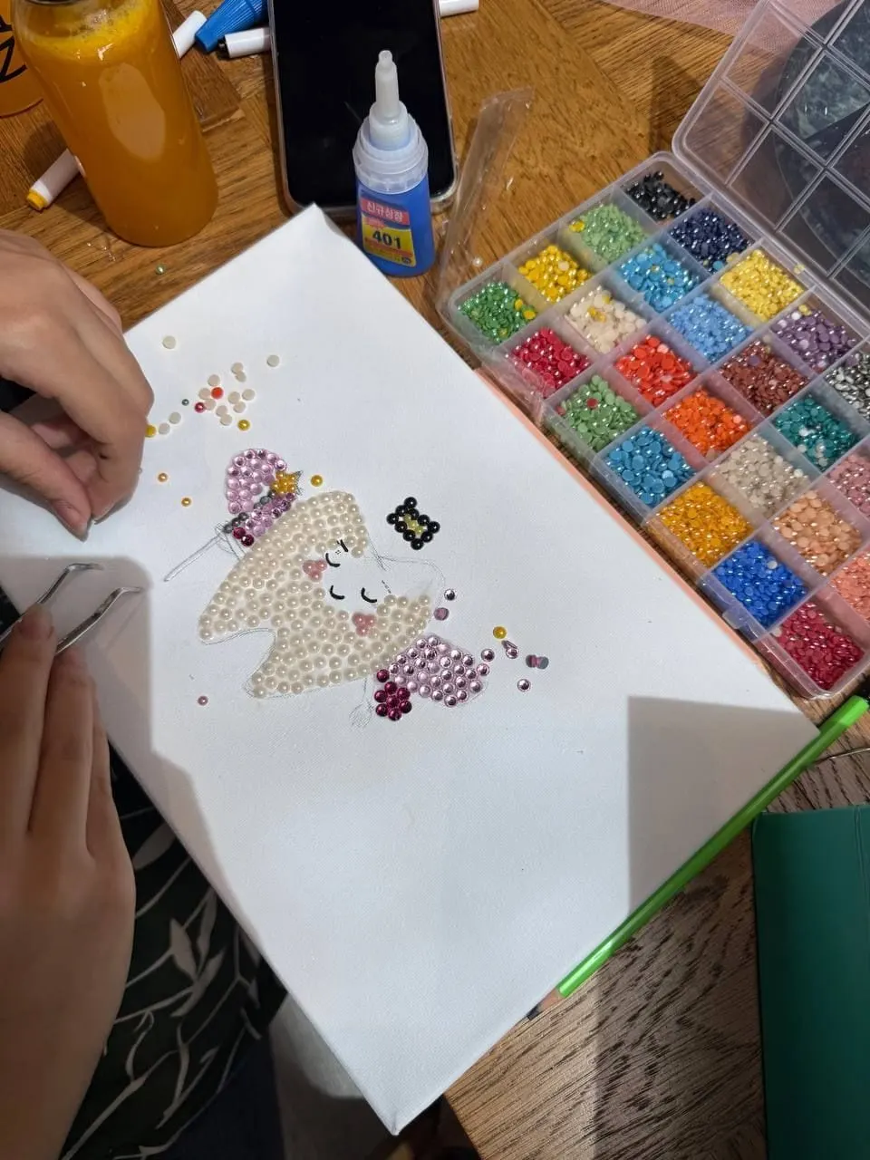 مشاركة تلصق الفصوص على رسمة بجانب علبة فصوص ملونة