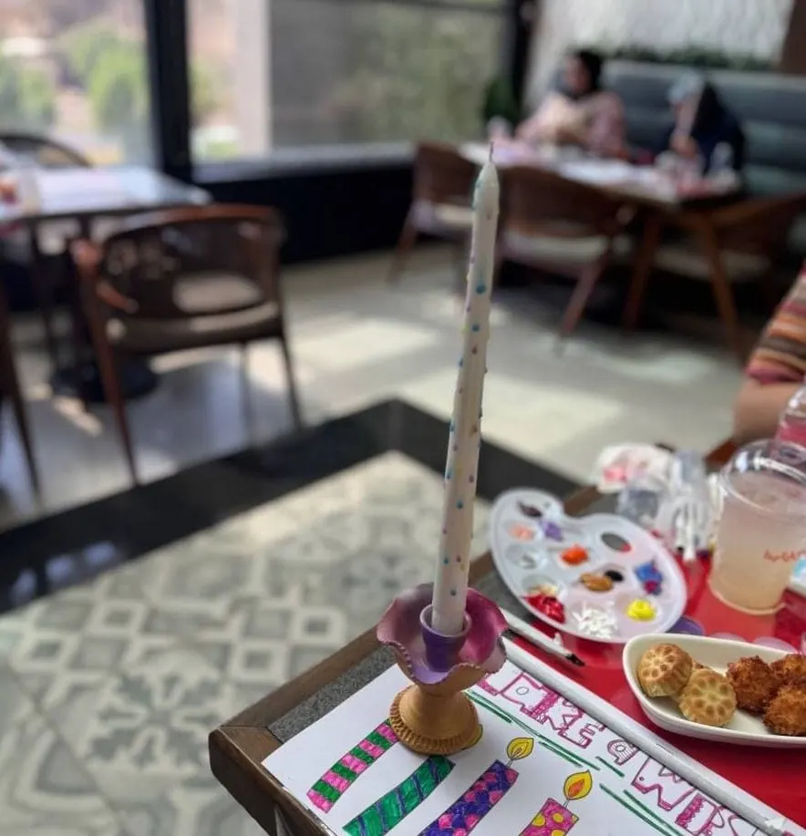 شمعة مرسومة على شمعدان بجانب لوحة ألوان