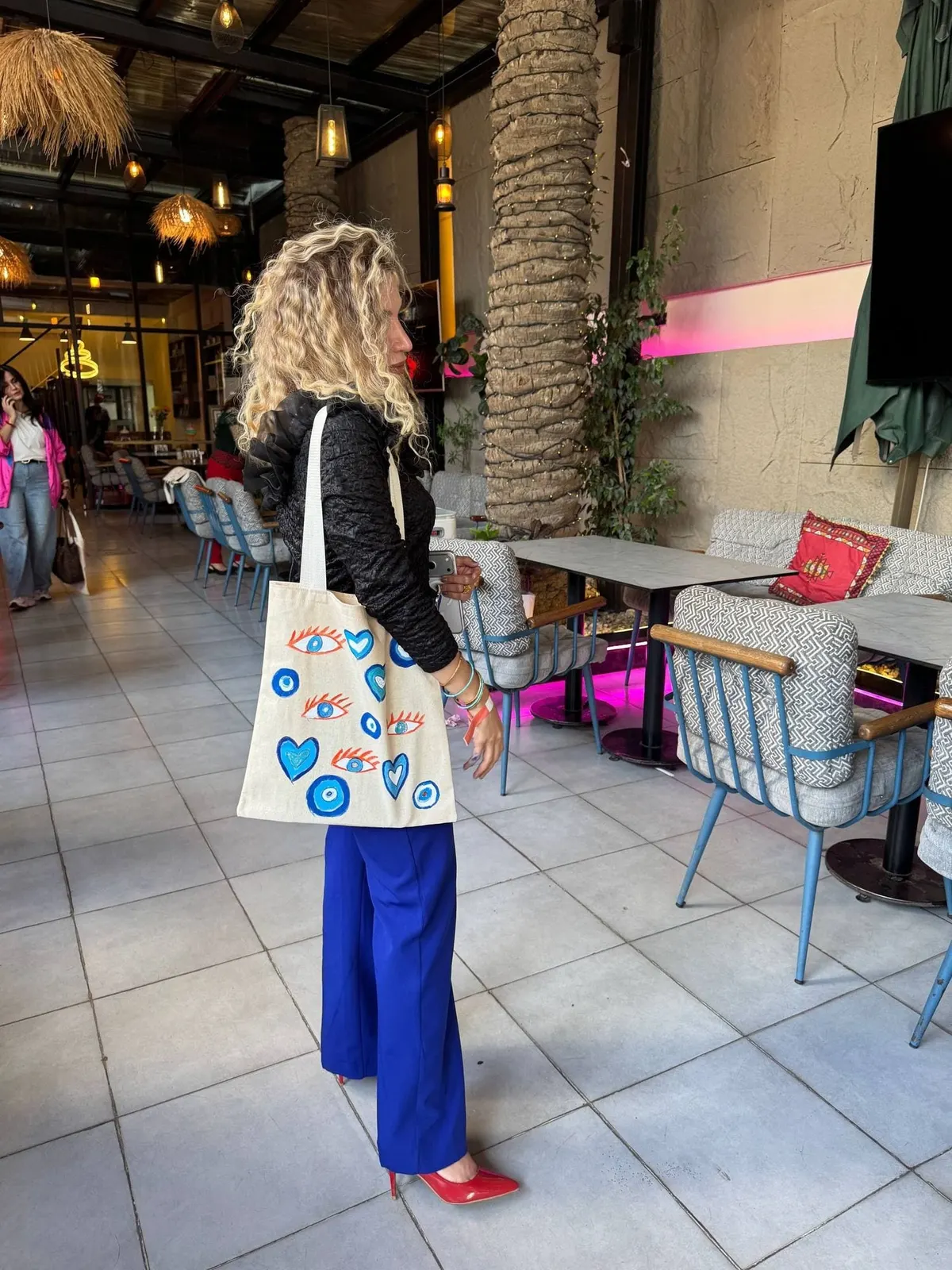 A participant carries her painted tote bag through the café