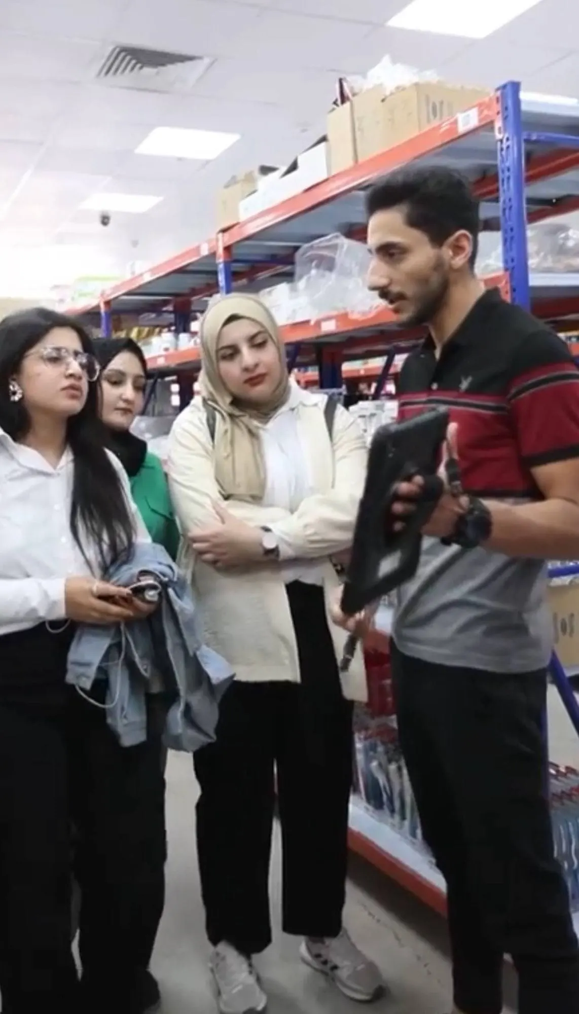 موظف من مسواك يشرح للمشاركات داخل المستودع