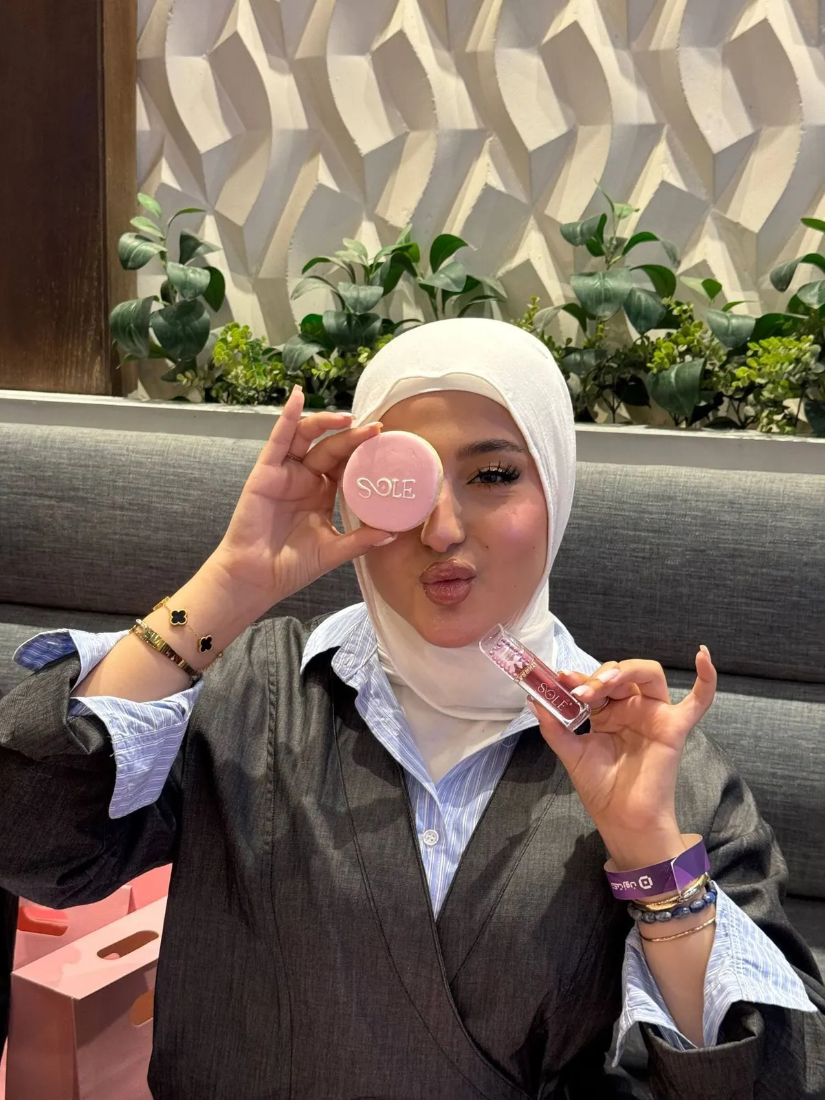 مشاركة تمسك علبة وردية مزيّنة أمام عينها
