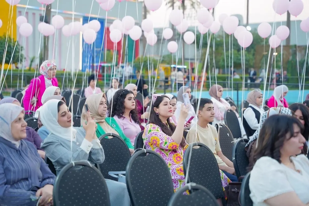 الحاضرات يجلسن في الساحة المزيّنة بالبالونات الوردية