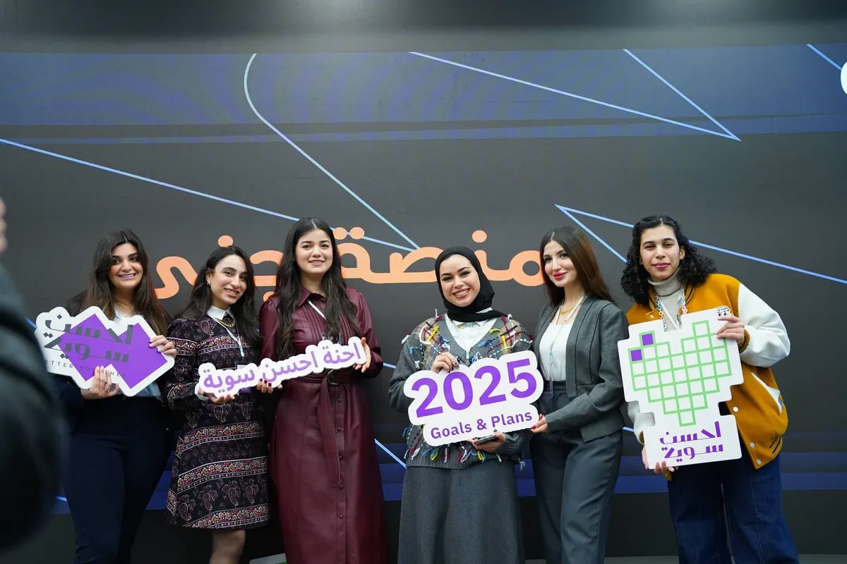 مشاركات يحملن لافتات «2025 Goals & Plans» أمام خلفية منصة جني