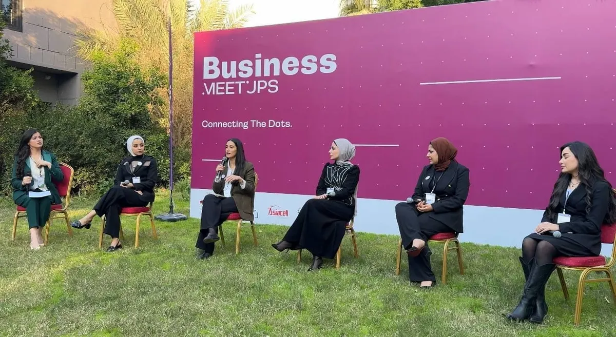 An open-air panel in front of a “Business Meetups” backdrop