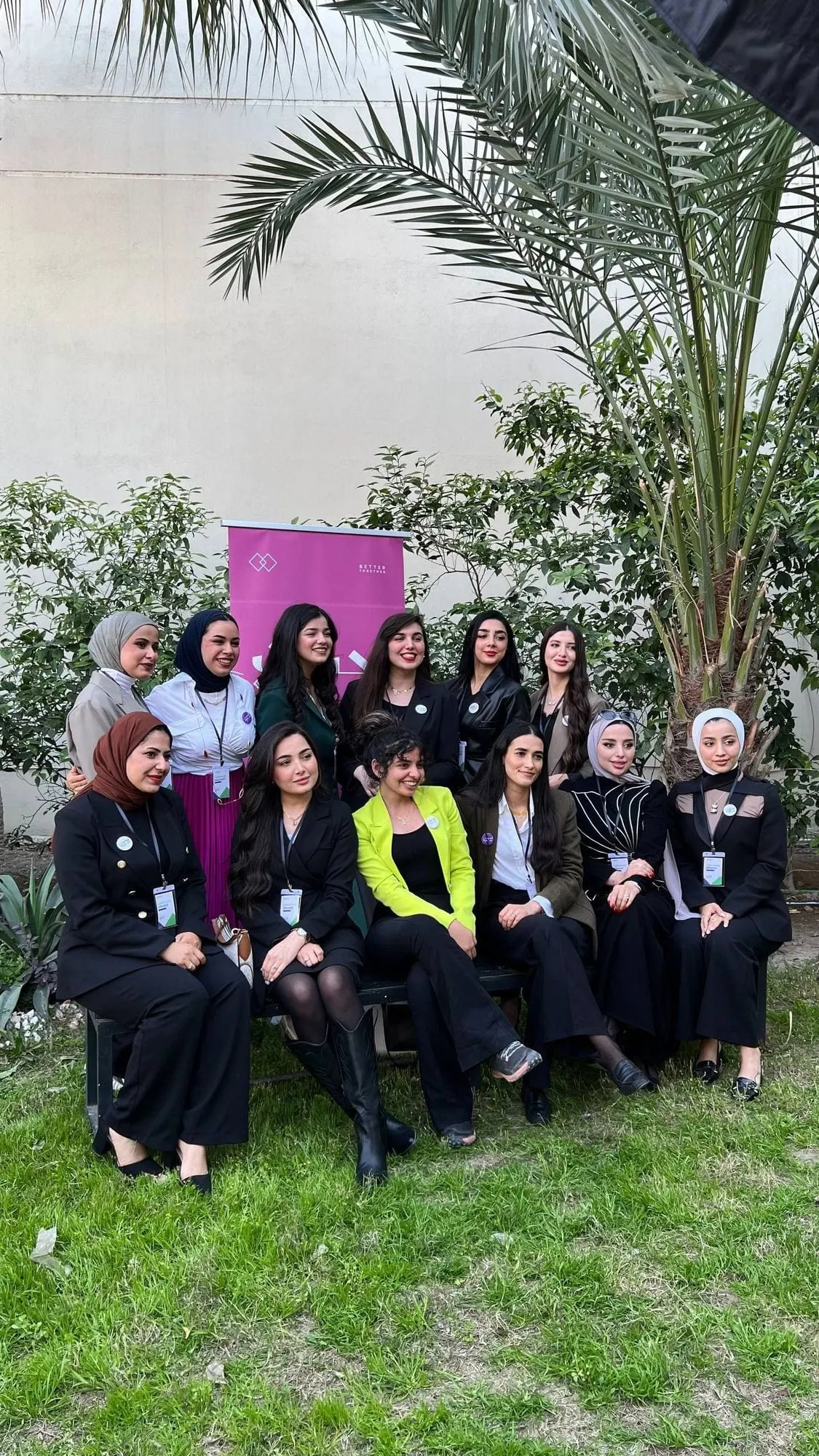 Participants sit on the grass for a group photo
